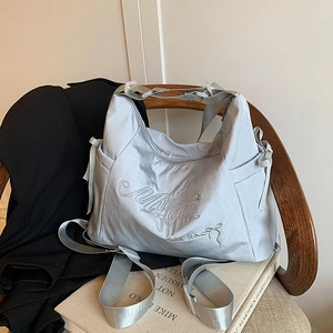 Silver nylon tote bag with bow embroidery on wooden chair for stylish daily commuting
