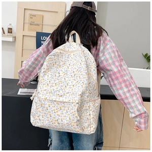 Detailed view of floral canvas backpack featuring yellow and blue flower patterns