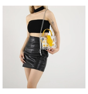 Detail van transparante PVC schoudertas met gele bies en geruite binnenzijde van de tas
