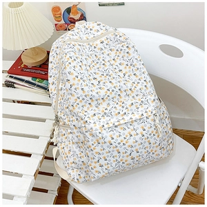 Minimalist floral nylon backpack for women with summer flower pattern on a white chair