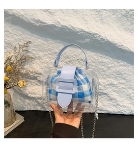 Detail van transparante PVC mini-tas met blauw lederen handvat en geruite tas met trekkoord