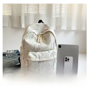 Dettaglio zaino bianco con trama FF a rilievo, ricami colorati e ciondoli decorativi
