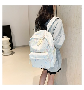 Primo piano dello zaino bianco con motivo a spruzzi colorati indossato da una modella