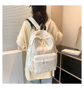 Dettaglio dello zaino bianco con linee ricamate e trama monogramma sul tessuto moda