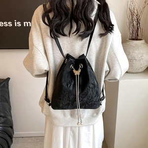 Black pleated drawstring bucket backpack with gold butterfly and pearl details for women
