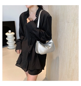 Silver metallic underarm bag with sparkling heart rhinestone buckle on female model