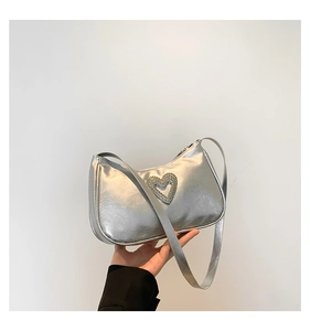 Detail of silver metallic hobo bag with rhinestone heart and wrinkled texture finish