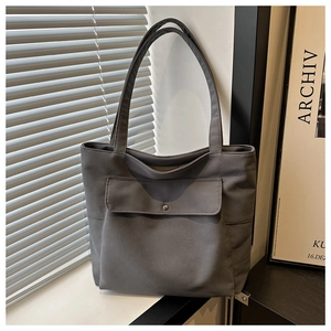 Gros plan du sac fourre-tout en toile gris foncé avec poche avant et bouton pression