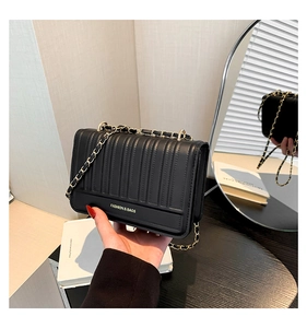 Détail d'un sac bandoulière en cuir noir matelassé avec lettrage doré Fashion & Bags