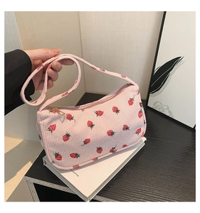 Détail du sac à bandoulière en velours côtelé rose avec motif fraises et zip doré