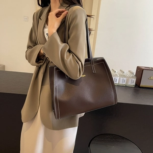 Deep brown large capacity tote bag with white contrast stitching and gold logo detail