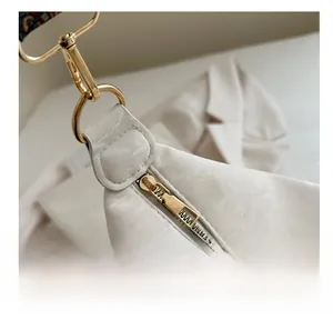 Detail of cream white faux leather texture with smooth golden zipper and hardware