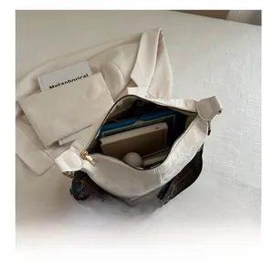 Interior view showing the large capacity of a white embossed shoulder bag with tech items