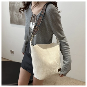 Detail of off-white tote bag with a colorful Bohemian style wide shoulder strap