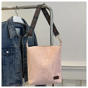 Detail of light pink wrinkled tote bag with colorful ethnic style woven shoulder strap