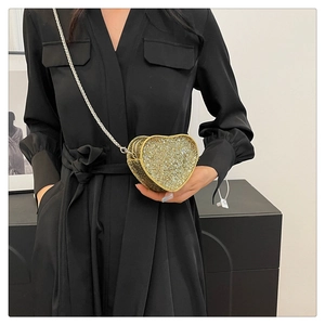 Close-up of heart-shaped mini bag with sparkling gold rhinestones and silver chain