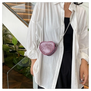 Detail of pink sequin heart-shaped mini crossbody bag with delicate silver metal chain
