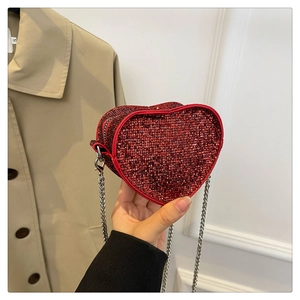 Detail of red heart-shaped bag with sparkling sequins and silver metal chain strap