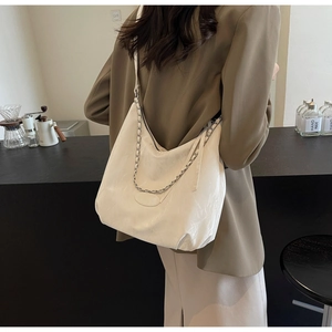 Detail of off-white PU leather hobo bag with silver chain and wide shoulder strap