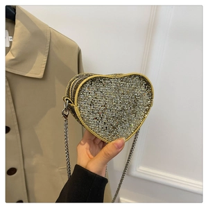 Close-up of heart-shaped mini crossbody bag with gold sequins and silver metal chain
