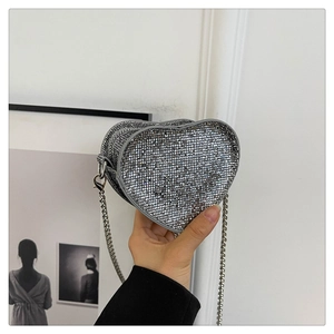 Detail of silver heart-shaped mini crossbody bag with sparkling rhinestones and metal chain