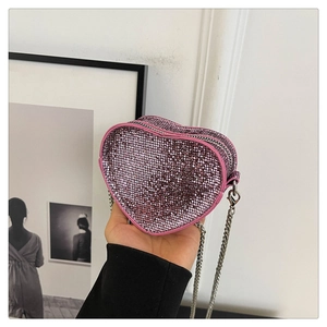 Detail shot of mini pink heart-shaped bag featuring shimmering rhinestone mesh and chain