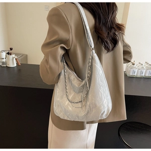 Detail of silver pleated tote bag with chic metallic texture and silver chain strap