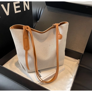 Nahaufnahme der gewebten Canvas-Tote-Bag mit braunen Ledergriffen in eleganter Geschenkbox