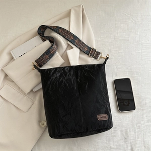 Chic black pleated shoulder bag with colorful ethnic strap and golden hardware