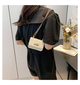 Dettaglio mini borsa a tracolla intrecciata crema con catena dorata e chiusura a vite