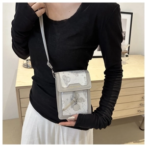 Dettaglio della mini borsa a tracolla con stampe di farfalle e stelle e ciondolo in metallo