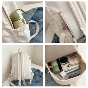 Dettaglio dello zaino bianco capiente con tasche laterali e zip antifurto posteriore