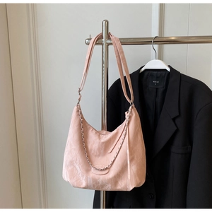 Detailed view of pink hobo bag with adjustable wide strap and silver chain accent