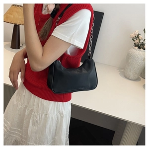 Detail of minimalist black faux leather bag with elegant silver chain and zipper closure