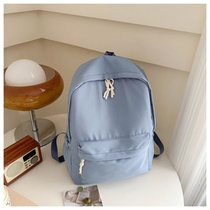 Zaino minimalista in tela celeste su tavolo bianco con arredamento in stile retrò