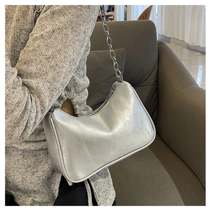 Silver metallic hobo underarm bag with thick chain strap shown on a model