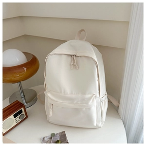 Dettagli dello zaino beige con tiranti intrecciati e tasche laterali portaoggetti