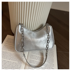 Detail view of silver underarm bag with bamboo texture and thick metal chain strap
