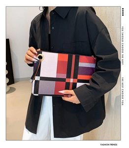 Detail of colorful geometric patchwork clutch bag with gold ring and carry strap
