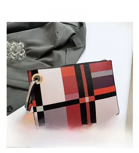 Detail view of the colorful checkered pattern and metal zipper on the faux leather clutch