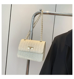 Détail du sac à bandoulière tressé crème avec texture en V et chaîne dorée