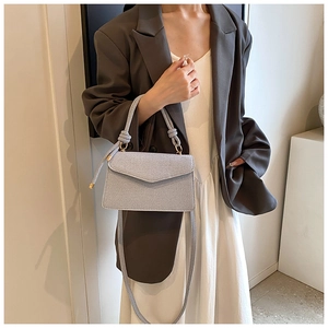 Détail d'un sac à main bleu clair tissé avec poignée nouée et finitions dorées