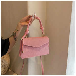 Détail du sac à main rayé rose et blanc avec poignée en corde épaisse et anneaux dorés