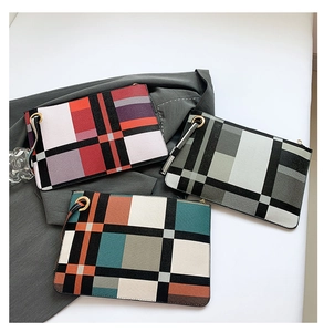 Close-up of geometric plaid envelopes clutch bags with wristlet and gold hardware