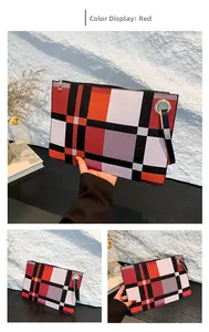 Detail of red and black checkered clutch bag with gold zipper and wrist strap