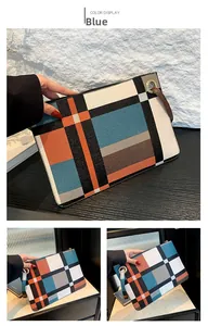 Detail of color block envelope clutch with metal ring handle and brown wrist strap