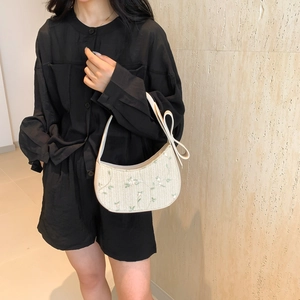 Chic cream woven dumpling bag with floral embroidery and large side bow detail