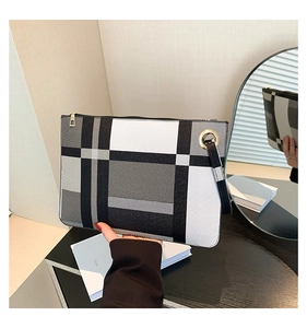 Close-up of geometric color block envelope clutch with gold zipper and hand strap