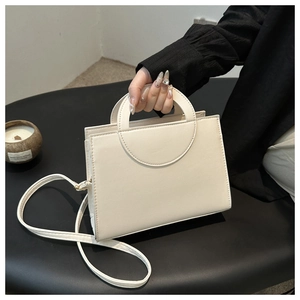 Detailed side view of off-white structured handbag featuring geometric hollow handle
