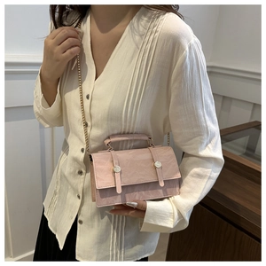 Detailed close-up of pink pleated leather bag with gold buckles and chain strap
